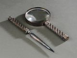 une loupe et un couteau posés sur une table