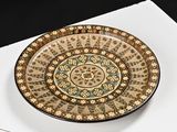a plate with a design on it sitting on a piece of paper