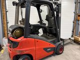 un chariot élévateur rouge garé devant une porte de garage