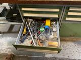 un tiroir rempli d'outils posé sur un établi dans un garage