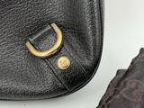 an image of a black purse with a gold ring on the handle