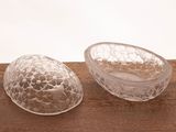 two pieces of glass sitting on top of a wooden table