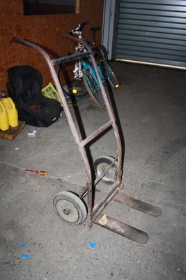 un diable sur lequel est posé un vélo, dans un garage