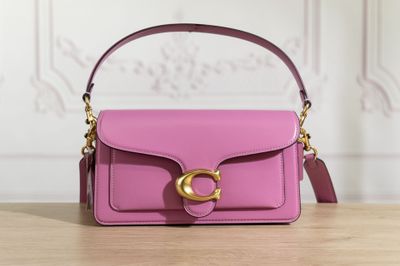 a close up of a pink handbag on a wooden table
