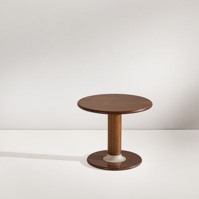 une petite table ronde avec un piètement en bois et un plateau blanc
