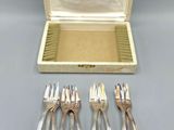six silver plated forks and a box with a lid