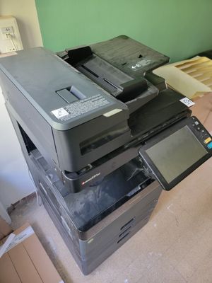 a stack of printers sitting on the floor in a room