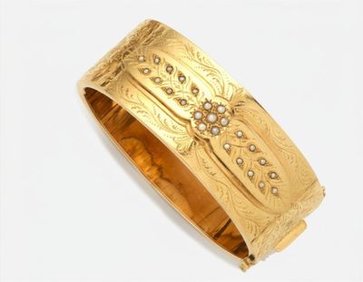 une image d'un gros plan d'un bracelet en or sur un fond blanc