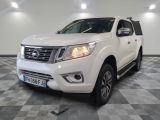 La Nissan Frontier blanche est garée dans une grande pièce.