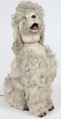 un chien en peluche assis sur une surface blanche