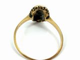 a close up of a gold ring with a black stone