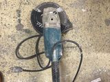 une petite machine posée par terre à côté d'une paire de chaussures