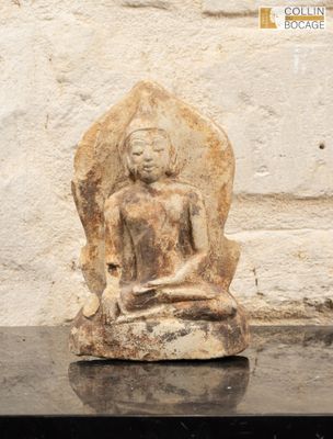 une statue en pierre représentant une personne assise sur un rocher