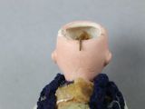 a small doll that has a broken egg in it ' s head