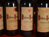 three bottles of red wine are lined up on a table