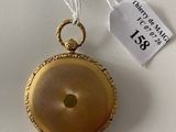 a small gold pocket watch with a tag on it