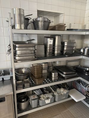 de nombreuses casseroles et poêles sur les étagères de la cuisine