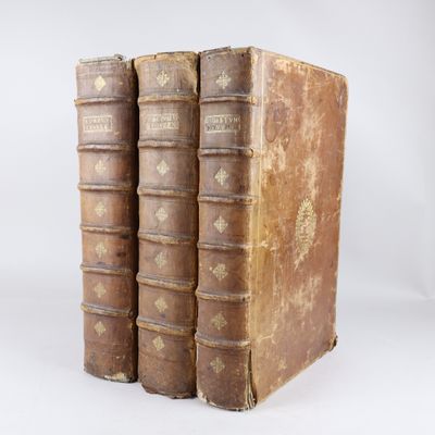 deux vieux livres posés l'un sur l'autre sur une surface blanche