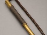 an old telescope with a wooden handle on a white surface