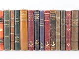 plusieurs vieux livres sont alignés sur une surface blanche