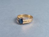 an image of a gold ring with a blue stone
