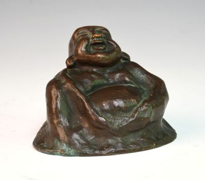 statue en bronze représentant un Bouddha souriant assis sur un socle blanc