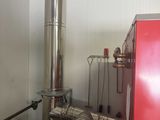 a red refrigerator and a metal stove in a room