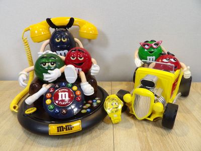 three toy cars and a telephone on a table