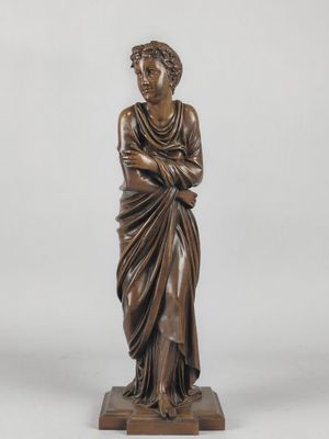 a bronze statue of a woman in a draped dress