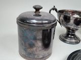 a silver cup sitting next to a silver cup on a table