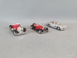 three toy cars sitting next to each other on a table