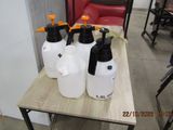 four plastic jugs sitting on top of a wooden table