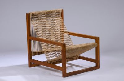 La chaise est en bois et possède une assise tressée.