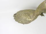 a statue of a bird that is sitting on a wall
