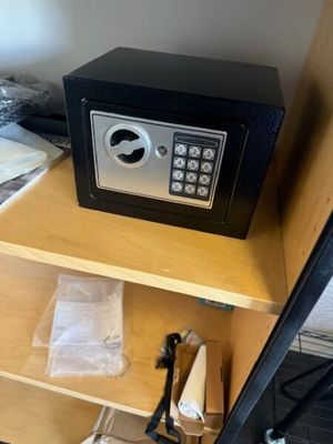 un petit coffre-fort posé sur une étagère dans une pièce