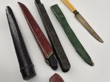plusieurs types de couteaux sont alignés sur une surface blanche