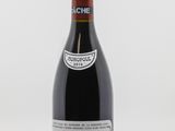 une bouteille de vin posée sur une table blanche