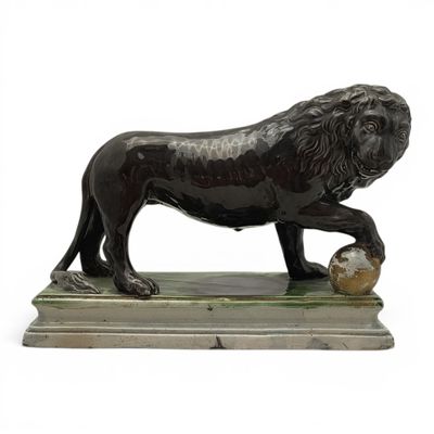statue d'un lion tenant une balle entre ses pattes