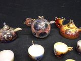 a lot of teapots and cups on a table