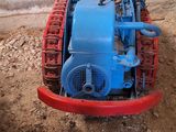 un petit tracteur bleu et rouge dans la terre