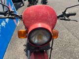 une moto rouge garée sur le bord de la route