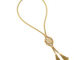 un collier en or orné d'un pompon sur fond blanc