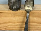 une cuillère et une tasse posées sur une étagère en bois