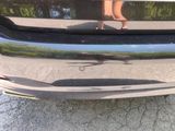 a woman standing on the back of a silver car