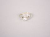 a white diamond ring on a white surface