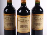 trois bouteilles de vin sont alignées sur une surface blanche