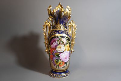 un vase avec des fleurs peintes dessus, posé sur une table