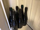 Plusieurs bouteilles de vin sont alignées sur une étagère dans une pièce