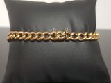 a close up of a gold chain bracelet on a pillow