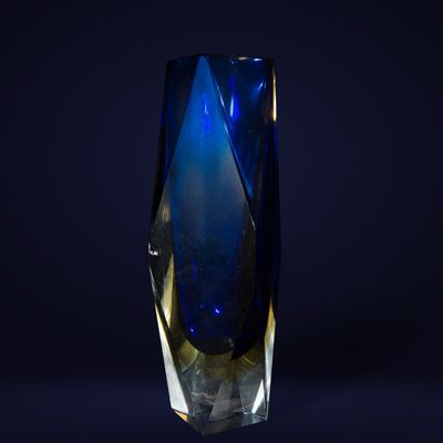 un vase en verre bleu sur fond noir